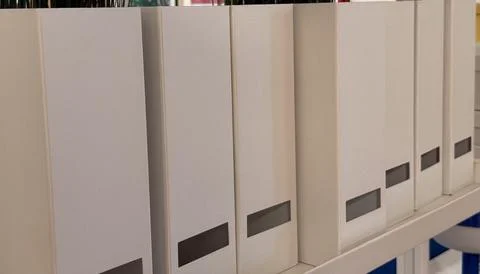 Row of white document boxes on a shelf for office storage and organization co Foto stock