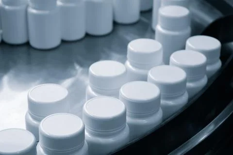 Row of white plastic containers with lids for medicines or vitamins or active Foto stock