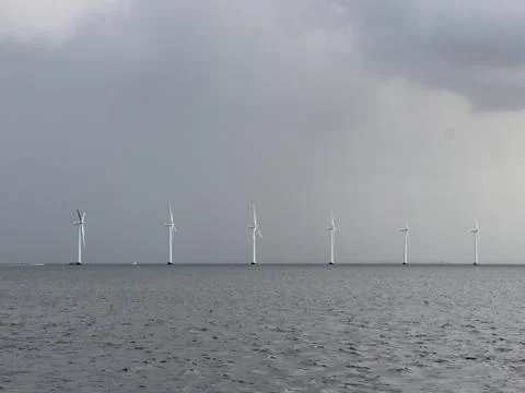 Row of White Windmills on the Ocean Stock Photos