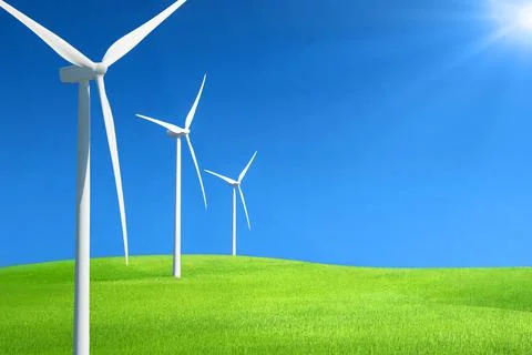 Row of wind generators in a row on top of a hill of green grass against deep Stock Photos