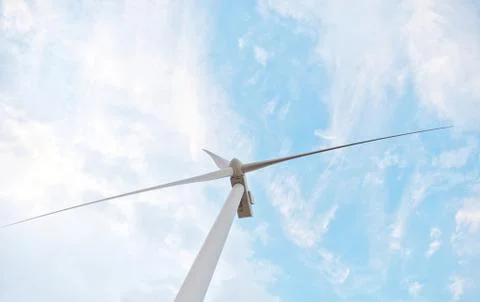 Row of wind power generators on blue sky background. Stock Photos