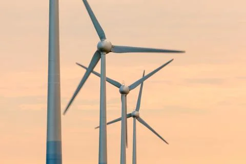 Row of wind turbines during sunset Фото