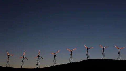 Row of wind turbines spinning at sunset. Stock Footage 88342940