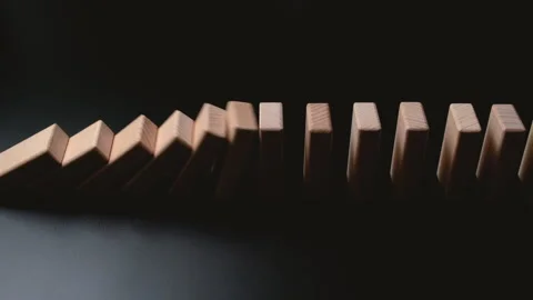 Row of wooden domino falling down against black background. Stock Footage 195189882