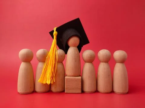 A row of wooden peg figures features a central figure elevated on a block w.. Stock Photos