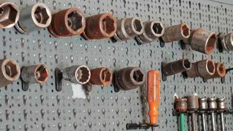 Row of Worn Socket Heads Mounted on Metal Pegboard in Garage Workshop Stock Footage 332828662