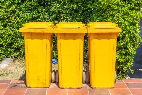 Row of yellow plastic trash bin for wate separation and recycling Stock Photos