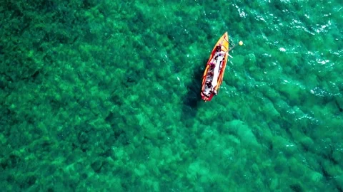 A rowboat and a motorboat float on turquoise water. Video stock 231781477