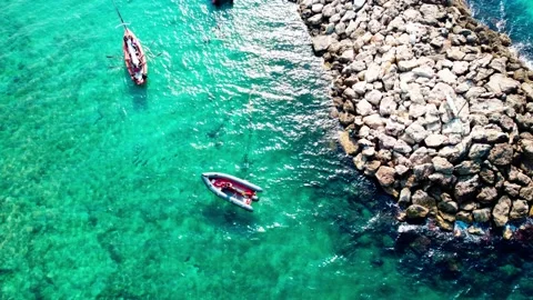 A rowboat and a motorboat float on turquoise water. Video stock 231781933
