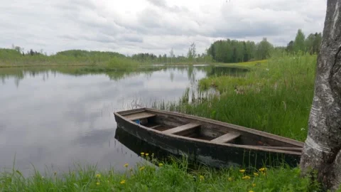 Rowboat with oars moored in quiet water Siežu Sieža ezers Sieza lake Latvia Stock Footage