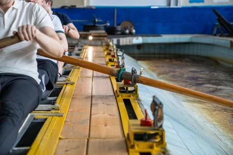 Rower arms in synchronized motion, paddling on simulator, strength flexibility Stock Photos