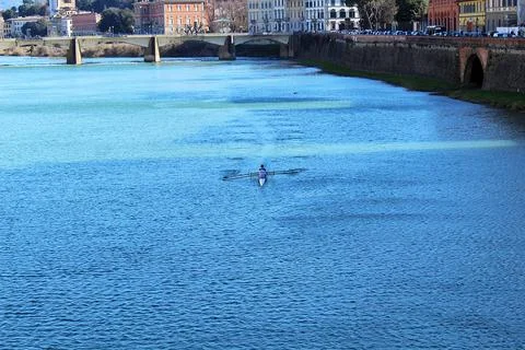 Rower in a single scull on the Arno River in Florence, Italy Photos