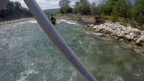 The rower works with an oar trying to level the boat and not sit on the rocks Stock Footage 128207628