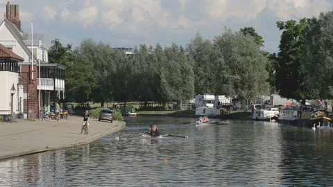 Rowers getting ready on the river Cam with narrowboats on opposite bank Stock Footage 91452935