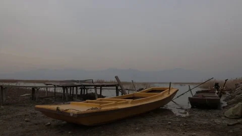 Rowing boat lying ashore at the river bank Stock Footage 75212997