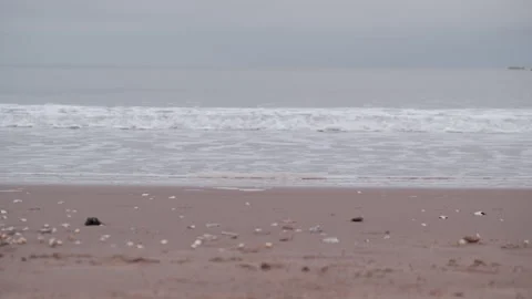 Rowing boat moving on horizon on a cloudy morning at Portobello Beach in Stock Footage 325853748