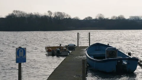 Rowing boats tied up to a dock during the cold winter months in Hornsea Stock Footage 123971925