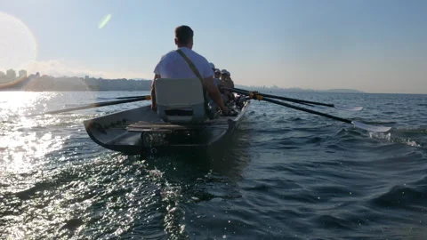 Rowing crew in a shell training together on the sea during a sunny summer Stock-Footage 344648323