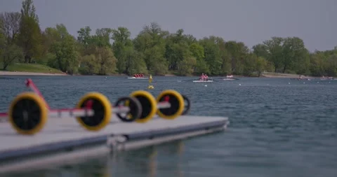 Rowing crews on lake with dock in foreground 스톡 동영상 332622027