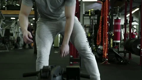 On rowing machine man in gym starts exercise on training. Stock Footage 92300408