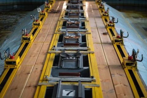 Rowing machine setup in pool, seats aligned for synchronized training. Water Stock Photos
