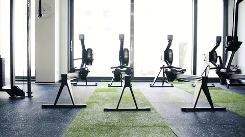 Rowing machines in empty modern gym room... | Stock Video | Pond5
