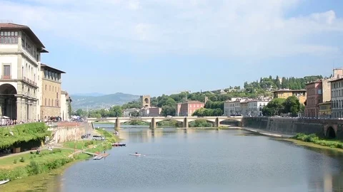 A rowing man in the Arno river in Florence in Italy during a sunny day Vídeos de archivo 83709960
