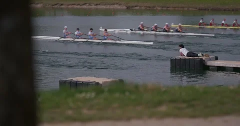 Rowing race in progress on Jarun Lake with man on dock 库存影片 332622056
