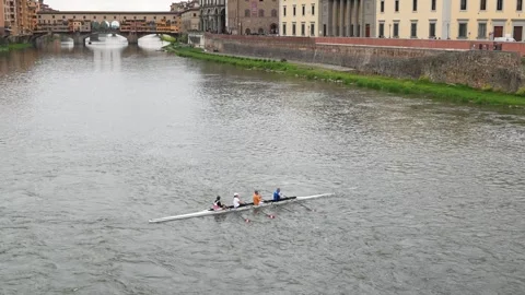 Rowing Team on the Arno River with Historic Florence Architecture in Background Stock Footage 334833050