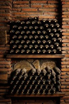 Rows of Aged Wine Bottles in a Rustic Cellar Stock Photos