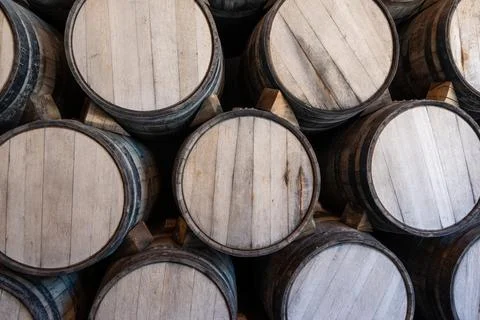 Rows of aged wooden barrels inside a traditional tequila distillery storage room Stock Photos
