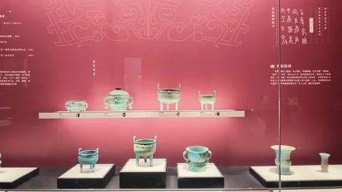 Rows of Archaic Bronze Ding Vessels Mounted on Crimson Display Wall Video stock 348069105