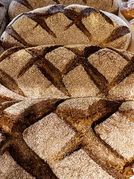 Rows of artisan bread loaves are presented in a local bakery, showcasing thei Foto stock