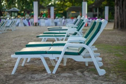Rows of beach chairs among trees in the evening Stock Photos