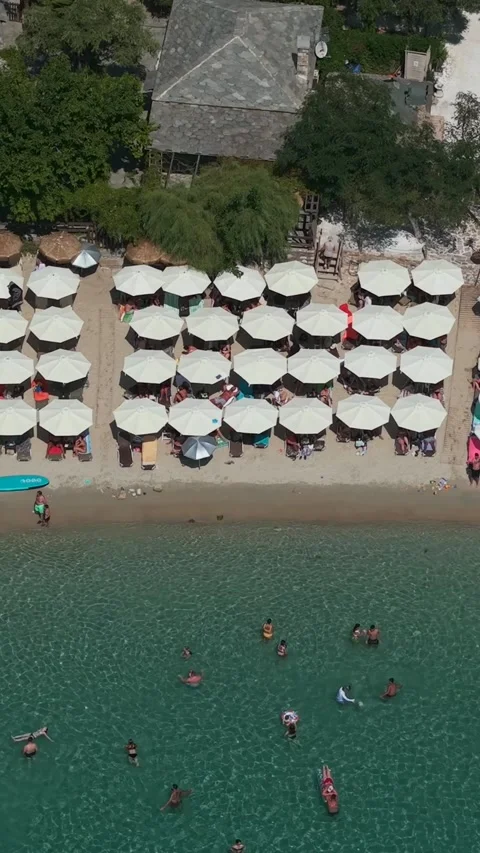 Rows of beach umbrellas, bathers and beach bars at Aliki, vertical Stock-Footage 347178754