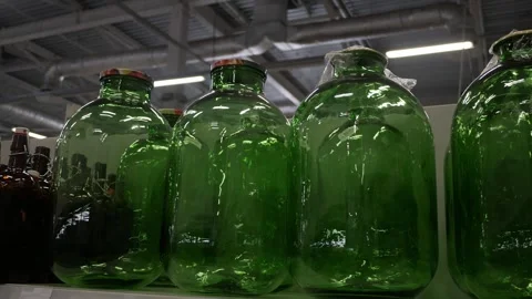 Rows of big clear glass jars and bottle in production on shelves, factory, store Stock Footage 276472791