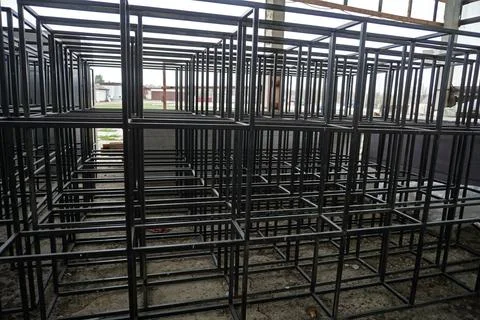 Rows of black metal frames inside a large warehouse. 写真素材