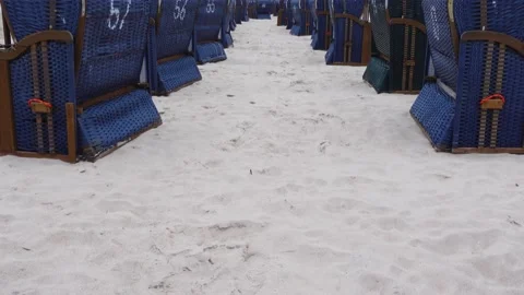 Rows of blue beach rattan huts on a beach on a cloudy day. Stock Footage 223346931