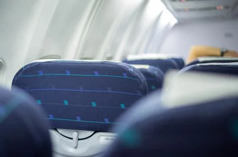 Rows of blue empty passengers seats in airplane Stock Photos