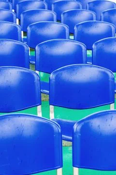 Rows of blue plastic stadium chairs in perspective Stock Photos