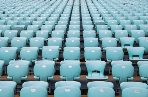 Rows of blue seats at empty open air stadium Stock Photos