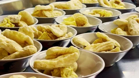 Rows of bowls display golden fried snacks ready for serving at a busy food .. Stock Footage 340059842