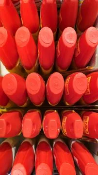  Rows of bright red containers, stacked neatly, product packaging. Stock Photos