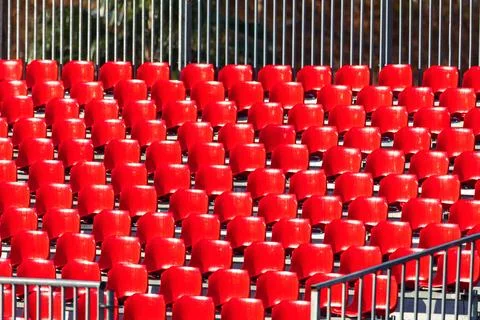Rows of bright red plastic chairs on stadium Stock Photos