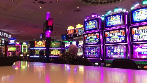 Rows of Bright Slot Machines and Jackpot Displays in a Modern Casino Interior Stock Footage 344387040