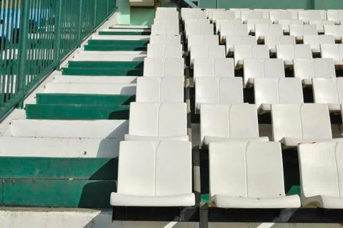 Rows of broken and stained white chairs in an outdoor auditorium Stock Photos