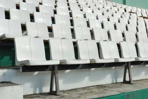 Rows of broken and stained white chairs in an outdoor auditorium Stock Photos