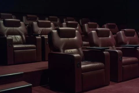 Rows of brown leather armchairs in an empty cinema hall in a movie theater du Stock Photos