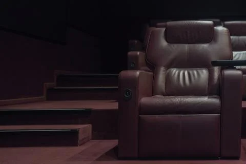 Rows of brown leather armchairs in an empty cinema hall in a movie theater du Stock Photos