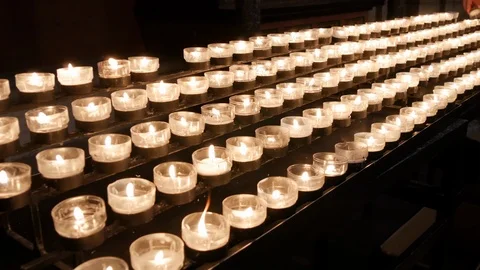 Rows of burning lit candles / tea lights in Catholic Cologne Cathedral Stock Footage 95095633